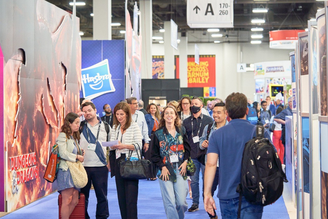 A group of different exhibitor stands on the Licensing Expo showfloor including WWE, Smiley, MGM, and Chia Pet.